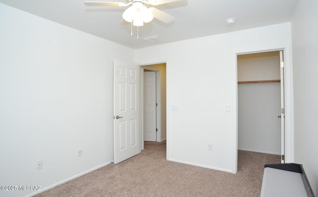 unfurnished bedroom featuring baseboards, visible vents, light carpet, and a spacious closet