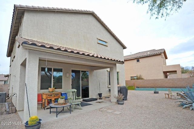 back of property featuring central AC, stucco siding, a fenced backyard, a patio area, and a tiled roof