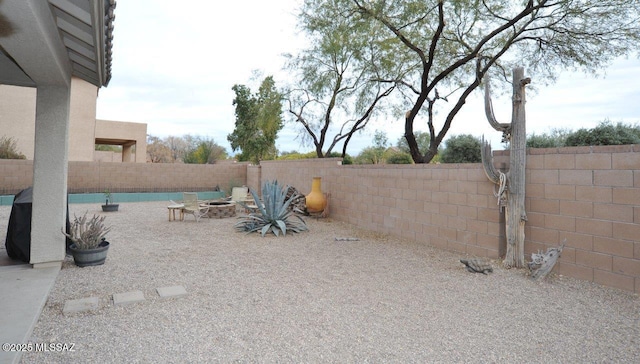 view of yard with a fenced backyard and a fire pit