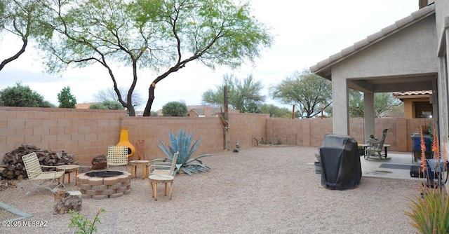 view of patio featuring a fenced backyard, a fire pit, and area for grilling