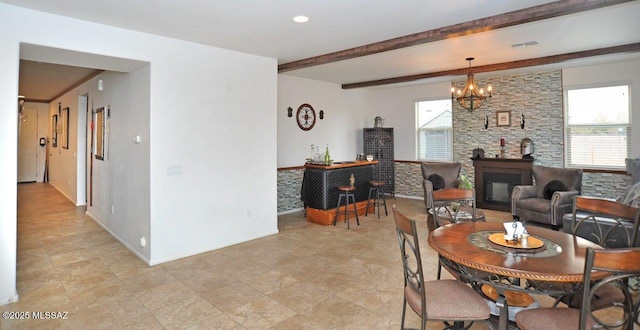 dining space featuring a glass covered fireplace, plenty of natural light, visible vents, and a chandelier