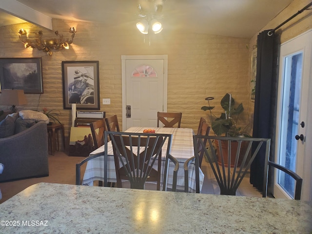 dining space featuring brick wall