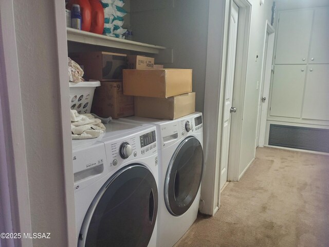 laundry room with washing machine and clothes dryer, laundry area, and light colored carpet