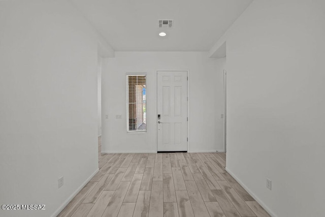 entryway with baseboards, visible vents, and light wood finished floors