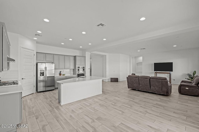 kitchen with visible vents, open floor plan, light countertops, gray cabinets, and appliances with stainless steel finishes