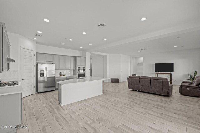 7956 S Desert Indigo Dr, Tucson, AZ 85747 - kitchen with stainless steel fridge, open floor plan, gray cabinets, light countertops, and light wood finished floors