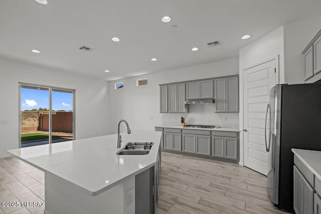 kitchen with a sink, gray cabinets, stainless steel appliances, and visible vents