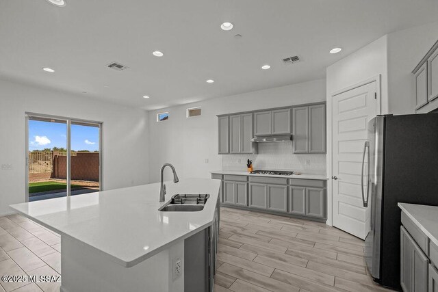 7956 S Desert Indigo Dr, Tucson, AZ 85747 - kitchen featuring gray cabinetry, freestanding refrigerator, gas stovetop, recessed lighting, and backsplash