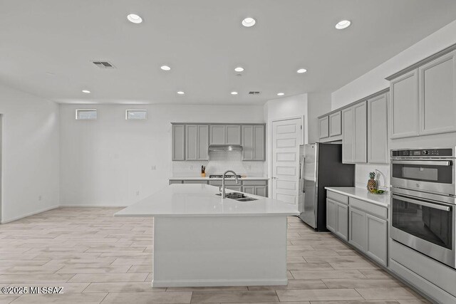 7956 S Desert Indigo Dr, Tucson, AZ 85747 - kitchen featuring gray cabinetry, appliances with stainless steel finishes, recessed lighting, light wood-style floors, and light countertops