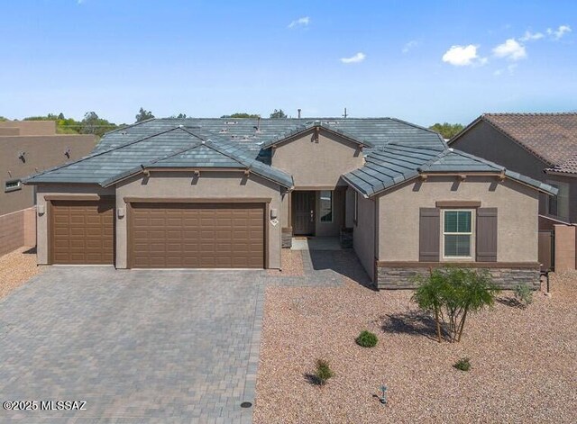 7956 S Desert Indigo Dr, Tucson, AZ 85747 - single story home featuring stucco siding, a garage, decorative driveway, a tile roof, and a mountain view