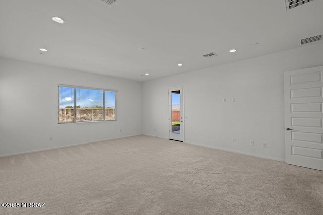 spare room with light carpet, recessed lighting, and visible vents