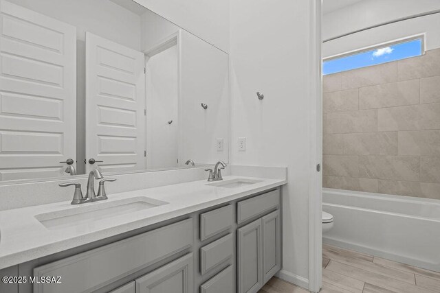 7956 S Desert Indigo Dr, Tucson, AZ 85747 - bathroom featuring double vanity, bathing tub / shower combination, and wood finished floors