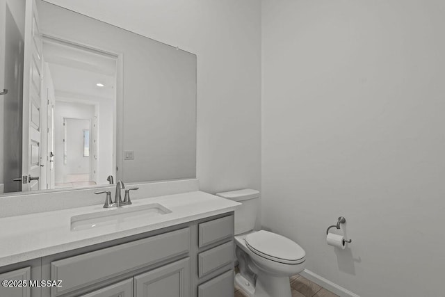 half bathroom with vanity and toilet