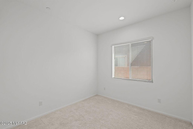 carpeted empty room featuring baseboards and recessed lighting