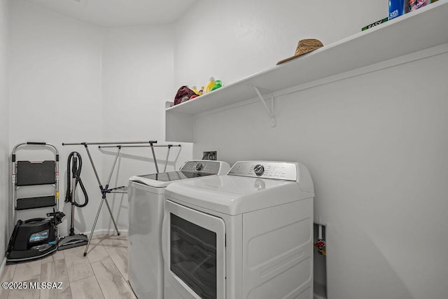 washroom with laundry area, washing machine and dryer, and baseboards