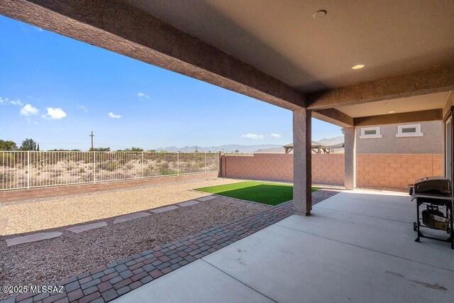 7956 S Desert Indigo Dr, Tucson, AZ 85747 - fenced backyard with a grill, a patio area, and a mountain view
