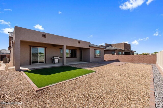 7956 S Desert Indigo Dr, Tucson, AZ 85747 - back of property with a fenced backyard, stucco siding, and a patio area