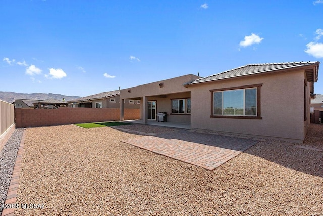 back of house with a patio, a fenced backyard, stucco siding, and a tile roof