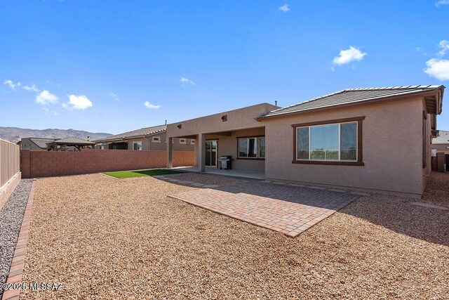 7956 S Desert Indigo Dr, Tucson, AZ 85747 - rear view of property with a fenced backyard, stucco siding, a patio, and a tiled roof