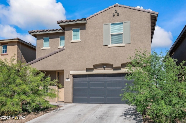view of front of property featuring a tiled roof, a garage, concrete driveway, and stucco siding