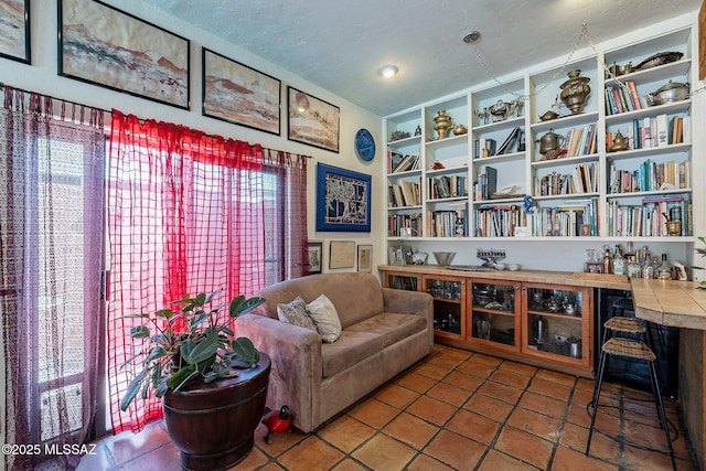 sitting room featuring a textured ceiling, built in shelves, and a wealth of natural light