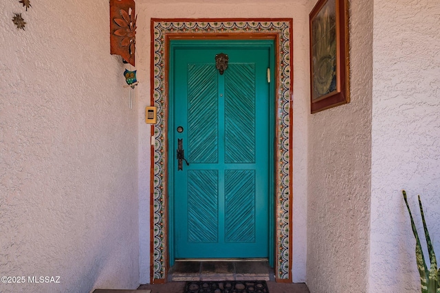 entrance to property featuring stucco siding