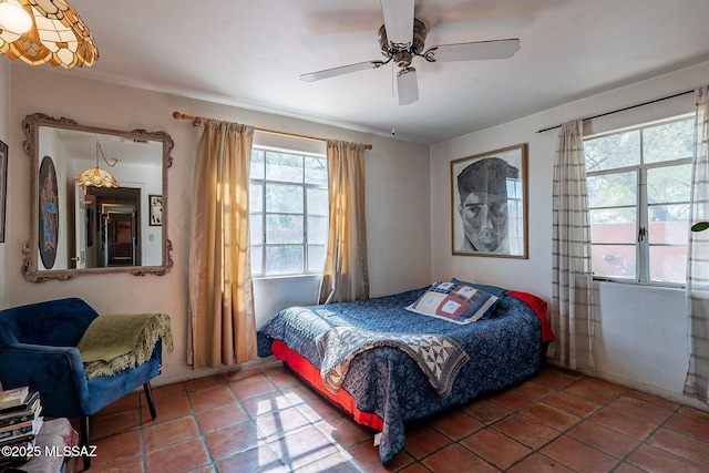 tiled bedroom featuring ceiling fan
