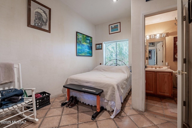 bedroom featuring light tile patterned floors and ensuite bath