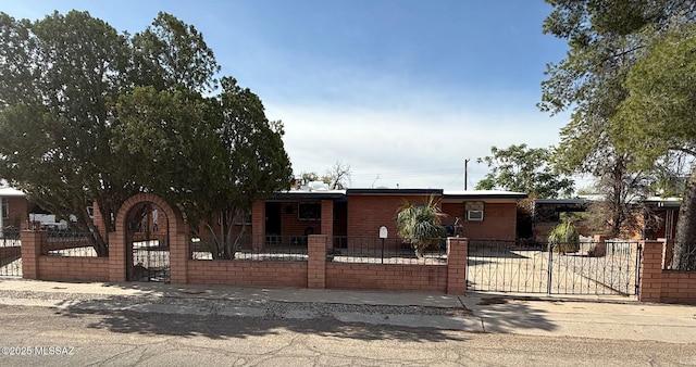 view of front facade featuring brick siding, a gate, and a fenced front yard