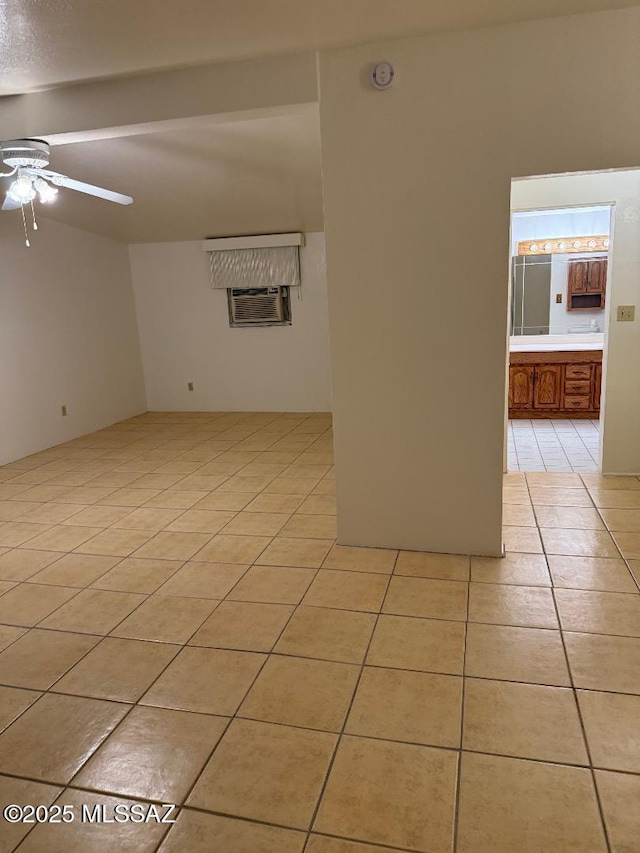 spare room with light tile patterned flooring, a ceiling fan, and a wall unit AC