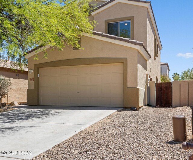 448 E Placita Nodo, Sahuarita, AZ 85629 - view of front of home featuring a tiled roof, a garage, fence, concrete driveway, and stucco siding