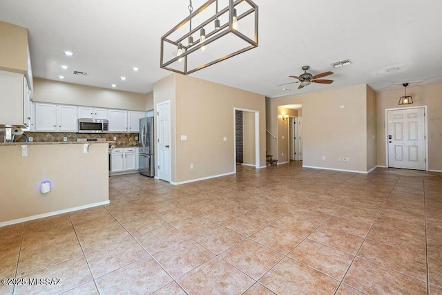 unfurnished living room featuring a ceiling fan, visible vents, light tile patterned floors, and recessed lighting