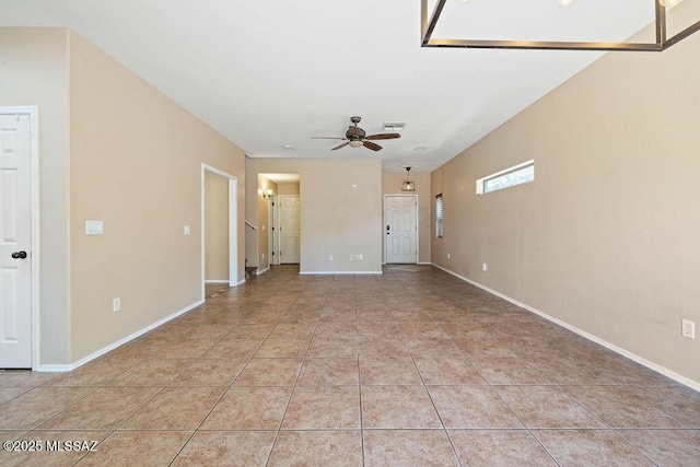 empty room featuring baseboards, a ceiling fan, light tile patterned flooring, and visible vents