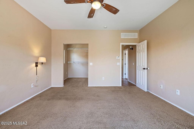 unfurnished bedroom with carpet flooring, baseboards, visible vents, and a spacious closet