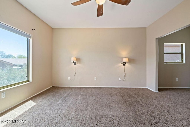 carpeted empty room featuring a healthy amount of sunlight, baseboards, and a ceiling fan