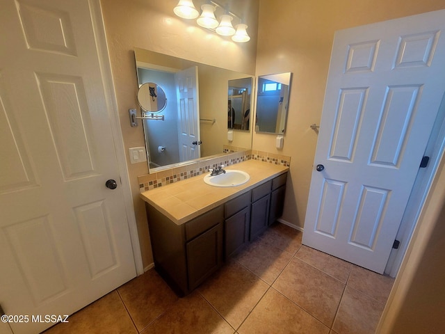 bathroom with vanity, tile patterned flooring, and baseboards