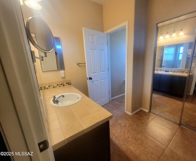 bathroom featuring vanity, baseboards, and tile patterned floors