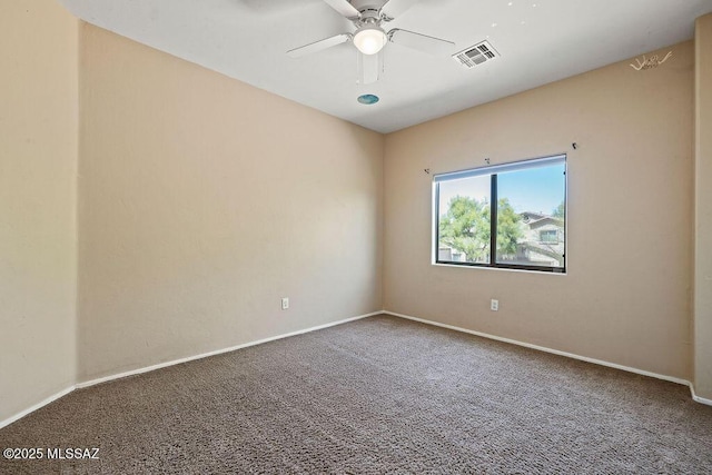 carpeted empty room with ceiling fan, visible vents, and baseboards