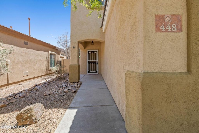doorway to property featuring stucco siding