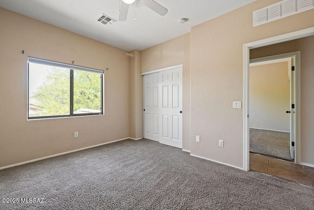 unfurnished bedroom with baseboards, visible vents, and carpet