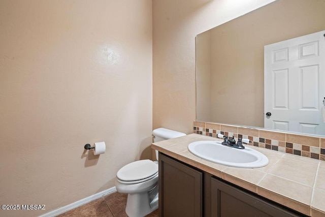 bathroom with toilet, baseboards, tile patterned flooring, and vanity