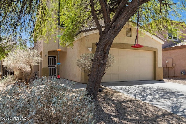 view of front facade featuring an attached garage, stucco siding, and driveway