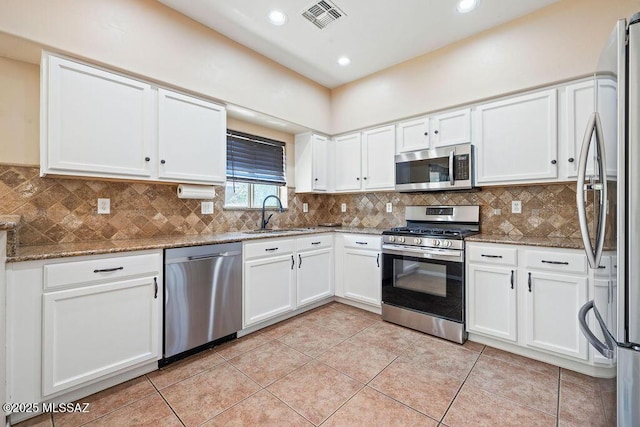 kitchen featuring stainless steel appliances, visible vents, white cabinetry, and a sink