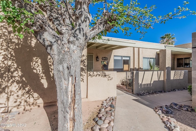 1734 N Van Buren Ave, Tucson, AZ 85712 - view of exterior entry featuring fence, a gate, and stucco siding