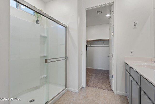 10337 S Pantano Knolls Dr, Vail, AZ 85641 - full bath with visible vents, a stall shower, vanity, baseboards, and a spacious closet