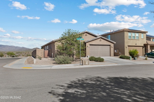 10337 S Pantano Knolls Dr, Vail, AZ 85641 - view of front facade with stucco siding, a gate, concrete driveway, an attached garage, and a mountain view