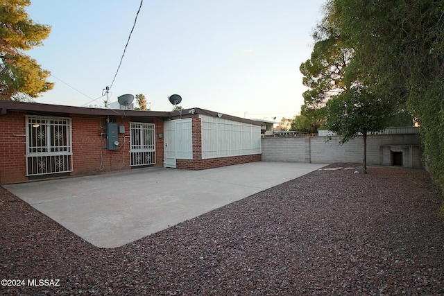 8133 E Colette Pl, Tucson, AZ 85710 - rear view of house featuring brick siding, a patio, and fence