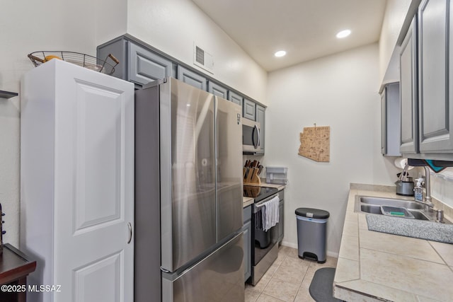 1810 E Blacklidge Dr Apt 827, Tucson, AZ 85719 - kitchen with gray cabinetry, appliances with stainless steel finishes, a sink, and light tile patterned floors
