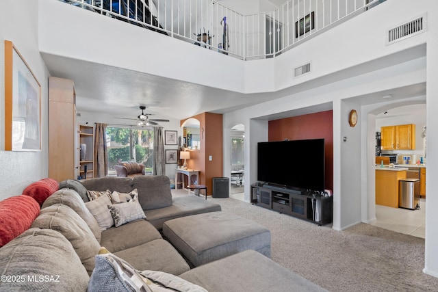 8014 S Wild Primrose Ave, Tucson, AZ 85747 - living area with arched walkways, light carpet, a ceiling fan, and visible vents