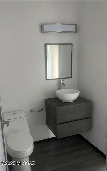 4270 E Broadway Blvd, Tucson, AZ 85711 - bathroom with toilet, baseboards, wood finished floors, and vanity